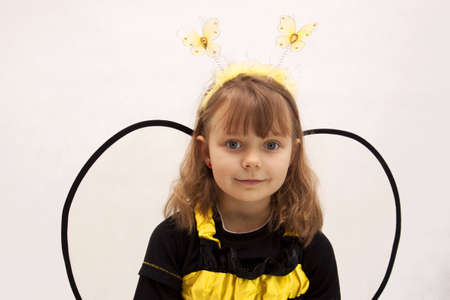 Girl dressed as a bee on white backgroundの写真素材