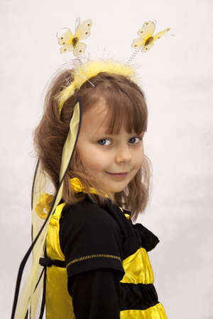 Pretty girl dressed as a bee on white backgroundの写真素材