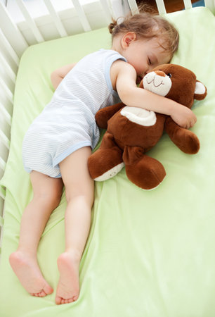 Sweet child sleeping with teddy bearの写真素材