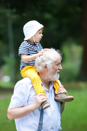 Grandfather and grandson having fun outdoorsの写真素材