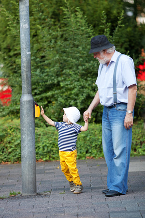 Grandfather and grandson crossing the street at the crosswalkの写真素材