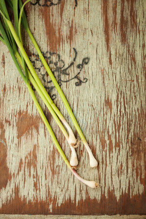 Image of green garlic on wooden board