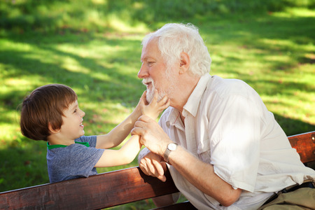 Grandchild pulling his grandfatherâs beardの写真素材