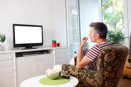 Image of a young man watching TVの写真素材
