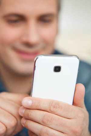 Young man using cell phone, shallow depth of field