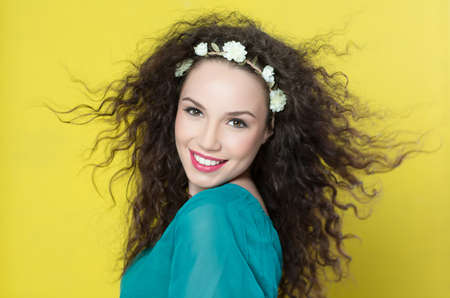 Portrait of beautiful young woman on yellow backgroundの写真素材