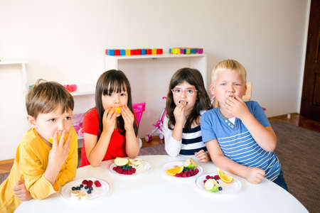 A Group of children having fruit snack break in the kindergartenの写真素材