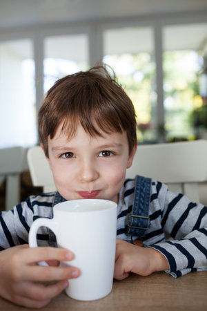 Adorable boy drinking milk or yogurt, shallow depth of fieldの写真素材