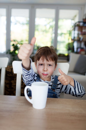 Adorable boy drinking milk or yogurt, shallow depth of fieldの写真素材