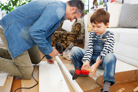 Father and son assembling furniture at homeの写真素材
