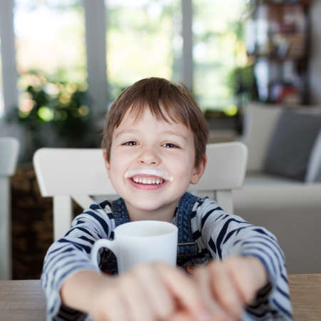Adorable boy drinking milk or yogurt, shallow depth of fieldの写真素材