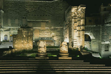 Ancient roman ruins in the Via dei Fori Imperiali in Rome illuminated at nightの写真素材