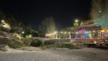 Party beach in the night light next to a rock outcropping.の写真素材