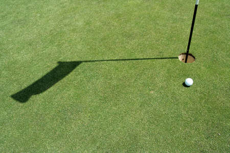 Golf green with flag and ballの写真素材
