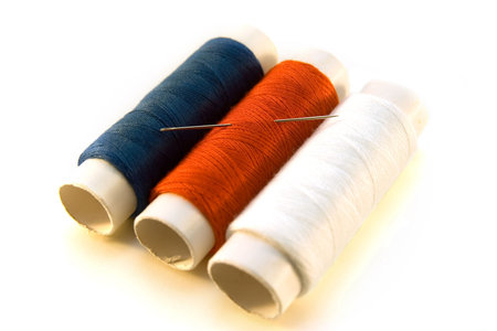 blue, red and white threads with needle 