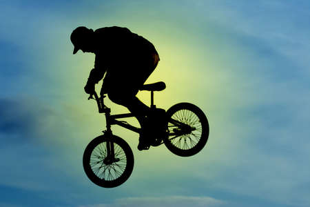 A mountainbiker flys across the skyの写真素材