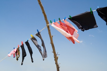 fresh laundry hanging on a clothesline in the blue skyの写真素材
