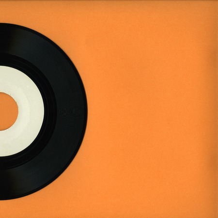 half of single record or lp with orange backgroundの写真素材