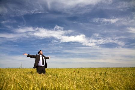 businessman with his arms wide open in rural fieldの写真素材