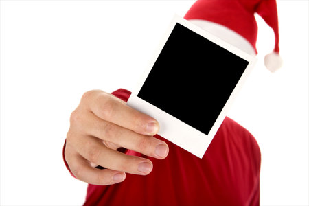 man in red shirt and santa hat holding a photo in front of his faceの写真素材