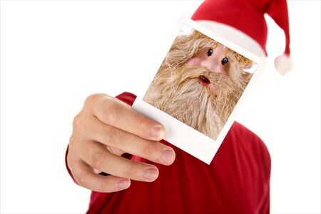 man in red shirt and santa hat holding a photo in front of his faceの写真素材
