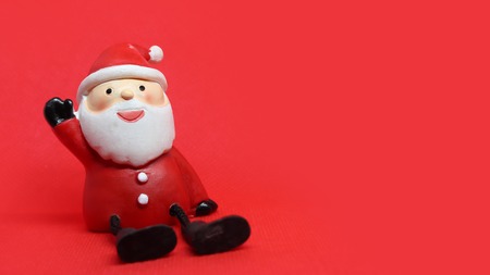 Cute santa doll in red textured background with copyspace to the rightの写真素材
