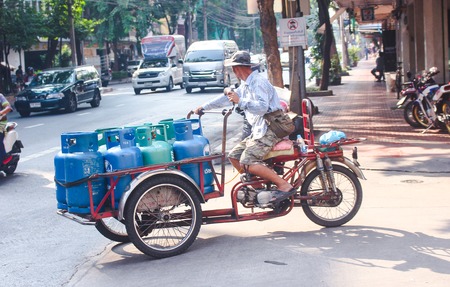 Bangkok, Thailand - October 2017: Male Thai transporting Bottled Gas with motorcicle in busy street of Bangkok.のeditorial素材