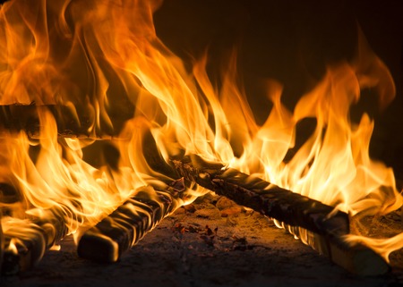 Close-up of roaring flames burning wood in fireplace. Romantic and mesmerizing flames.の写真素材