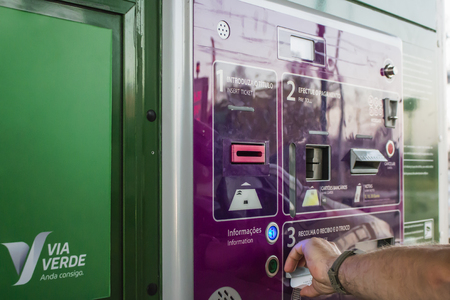 Leiria, Portugal - August 2018: Man getting receipt from unmanned toll both in portuguese highway.のeditorial素材