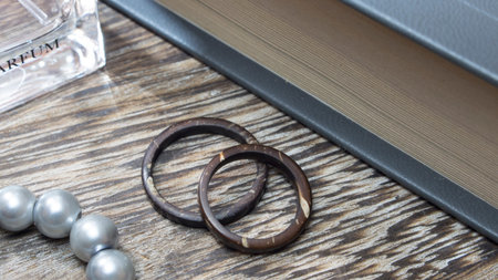 Artisan wedding ring bands, handmade from coconut in wooden table with props. Love and union...