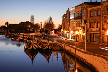 Aveiro, Portugal - April 2019: Tradicional Moliceiro boats docked in the main canal near Rossio after sunset.のeditorial素材