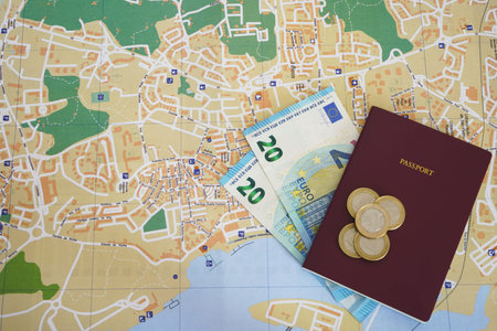 Horizontal photo of undefined red passport with banknotes and euro coins money on top of a local...