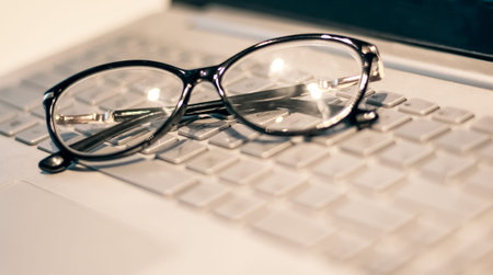 Eye glasses on office computer keyboard, Close up eye glasses, office computer, Gray tone, fashion...