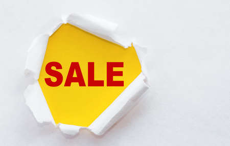 Torn white paper with a word Sale! discounts and promotionsの写真素材