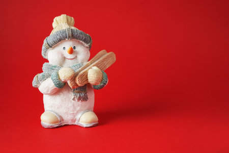 Handsome snowman with skis on red background, Christamas concept.の写真素材