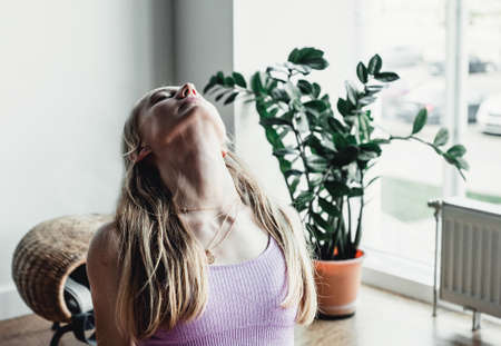 Portrait healthy women in sport clothes in yoga studio stretching neck.の写真素材