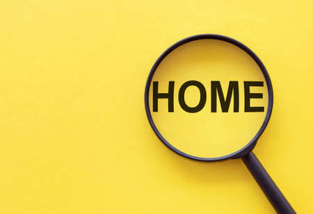 The word home is written on a magnifying glass on a yellow background.の写真素材