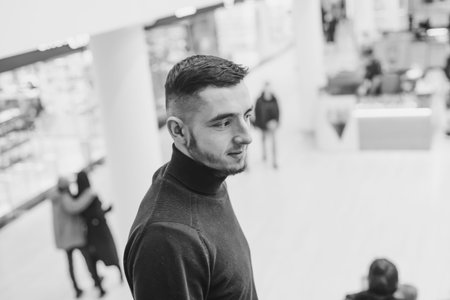 Black and white portrait young man on shopping mall background