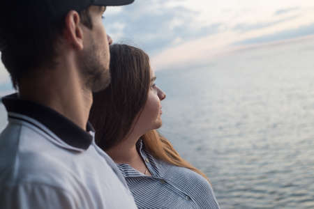 Beautiful couple on the beach. A man hugs a woman and they look at the horizonの写真素材