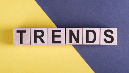 Wooden Blocks with the text trends. on yellow and gray backgroundの写真素材