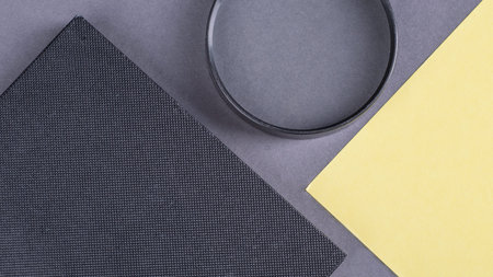 Notebook with a magnifying glass and paper for notes on a gray background