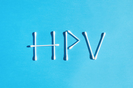 The word Human Papiloma Virus HPV is lined with cotton sticks on a blue background