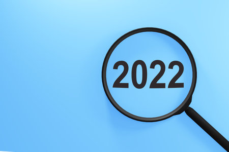 Magnifying glass with the word 2022 on blue background