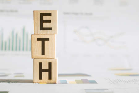 Text ETH Ethereum on wooden cubes on chart background. Ripple. cryptocurrencies. Buy and sell.の写真素材