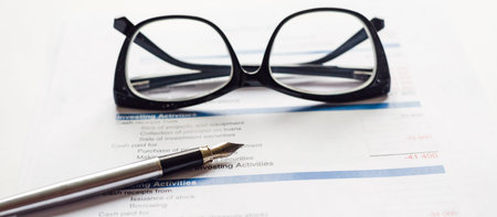 Financial documents with pen and glasses in business work on office desk