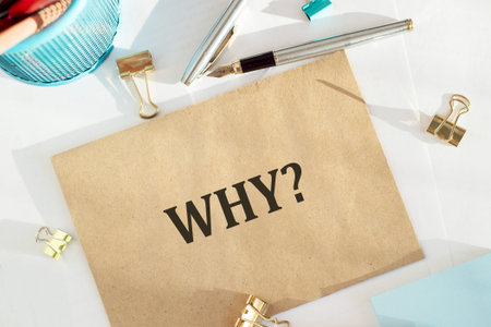Brown Paper Envelope With The Question Why Written On It Surrounded By Office Supplies