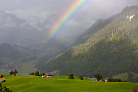 Rainbow above misty hills in Switzerlandの写真素材