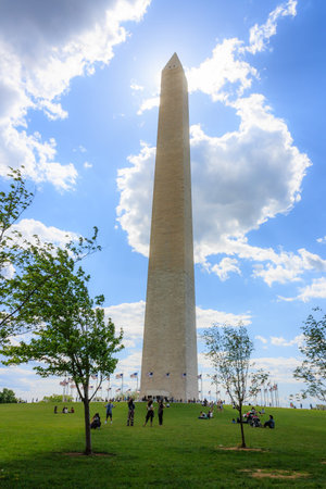 Washington monument in Washington DC, with sun and glowing white clouds directly behind the peak.のeditorial素材