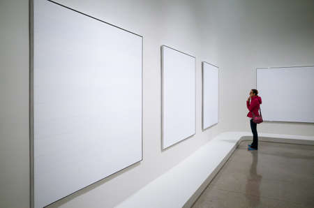 Interior of the Solomon R. Guggenheim museum, young woman looking at part of Agnes Martin exhibition - October 9, 2016, 5th Ave, New York City, NY, USAのeditorial素材