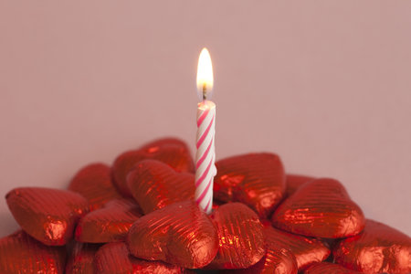 Birthday candle and chocolate heartsの写真素材